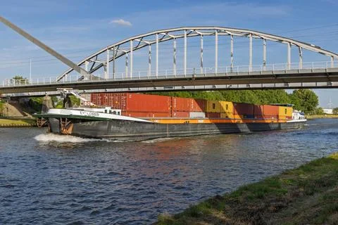 A large container barge named "Explorer" navigates a waterway under a modern Stock Photos