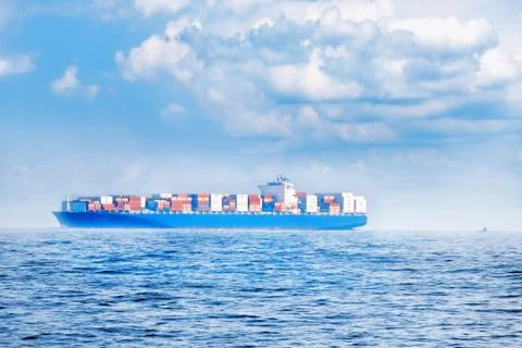 Large container cargo ship in the ocean, side view. Stock Photos