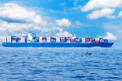 Large container cargo ship in the ocean, side view. Stock Photos