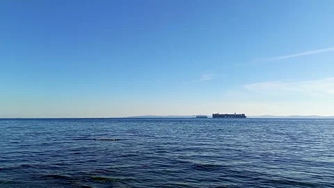 Large Container Cargo Ship Sailing on Deep Blue Sea Under Clear Sky Background Stock Footage 336344726