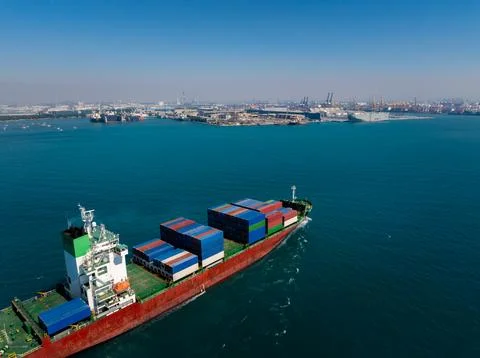 Large Container Cargo Vessel Carrying Freight Across Blue Ocean Waters Near.. Stock Photos