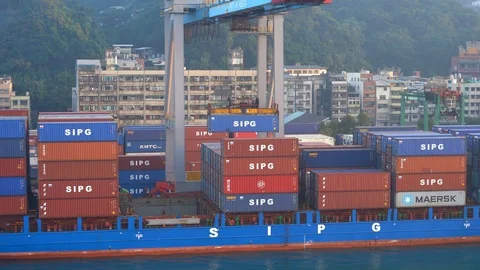 Large container cranes in the port load multi-colored containers onto an industr Stock Footage 122023441
