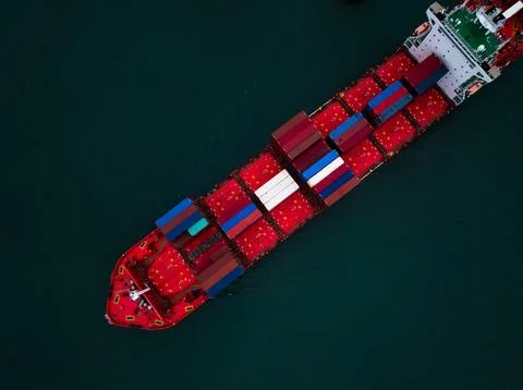 Large Container Ship Carrying Cargo Across The Deep Ocean Water High Angle Sh Stock Photos