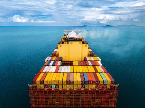 Large Container Ship Carrying Cargo Across The Open Ocean Under Cloudy Skie.. Fotos Stock