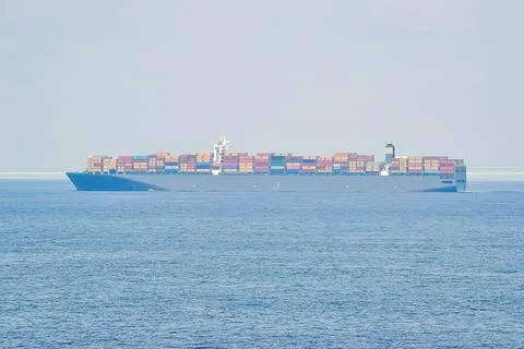 Large Container Ship with Colorful Containers on Calm Sea Stock Photos