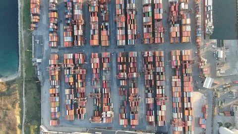 A large container ship is docked at a port Stock Photos
