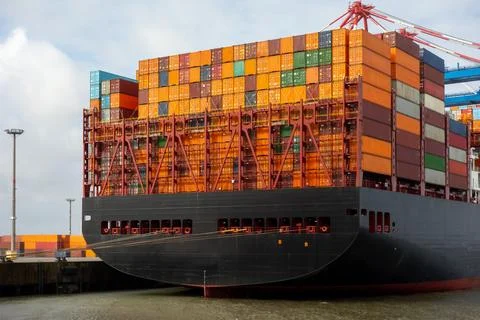 Large container ship loaded with colorful cargo containers docked at indust.. Photos