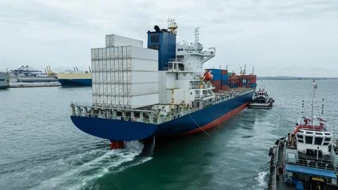 Large Container Ship Maneuvering Through Busy Industrial Harbor High Angle Sh Stock Photos