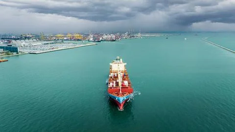 Large Container Ship Navigating Busy Industrial Harbor In Chonburi Thailand.. 库存照片