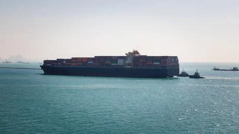 Large Container Ship Navigating Coastal Waters With Tugboat Assistance Wide.. Stock Photos