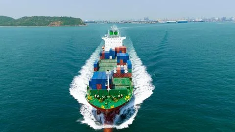 Large Container Ship Navigating Coastal Waters Under Blue Sky High Angle Shot Stock Photos