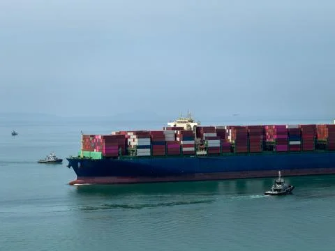 Large Container Ship Navigating Coastal Waters Escorted By Tugboats High An.. 스톡 사진