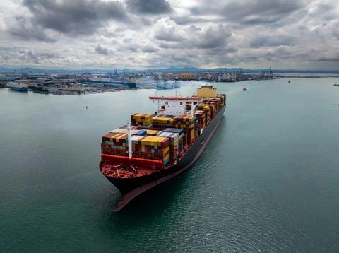 Large Container Ship Navigating Coastal Waters Toward Industrial Harbor Tha.. 库存照片