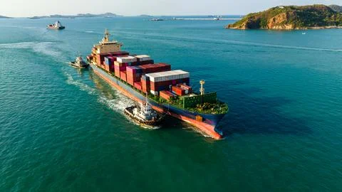 Large Container Ship Navigating Coastal Waters Escorted By A Tugboat Near S.. Stock Photos