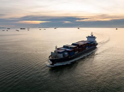 Large Container Ship Navigating The Ocean At Sunset Near Chonburi Thailand .. Stock Photos