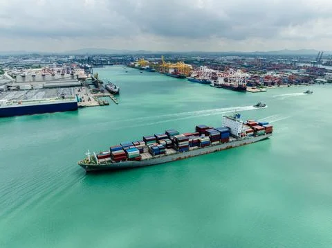 Large Container Ship Navigating Shipping Channel Toward Industrial Port Coa.. Stock Photos
