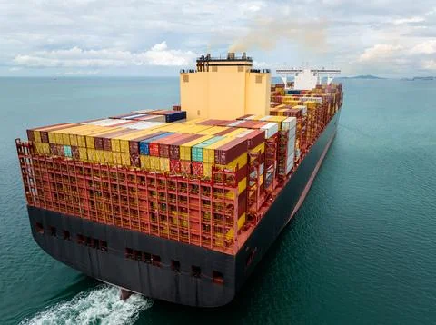 Large Container Ship Navigating Through Open Ocean Waters Under A Cloudy Sk.. 写真素材