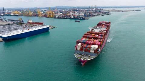 Large Container Ship Navigating Through Busy Industrial Harbor At Laem Chab.. Stock Photos