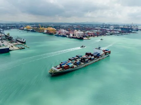 Large Container Ship Navigating Through Industrial Harbor Port Long Shot Stock Photos