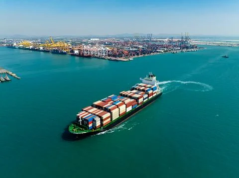 Large Container Ship Navigating Toward Industrial Harbor Port Facility Wide.. Foto stock