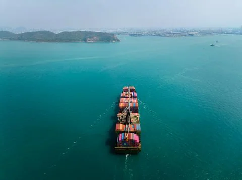 Large Container Ship Navigating Turquoise Coastal Waters Near Si Racha Chon.. Foto stock