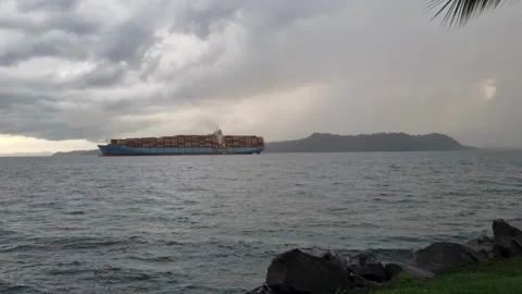 Large container ship sailing across the ocean under a cloudy stormy sky Stock Footage 344891412