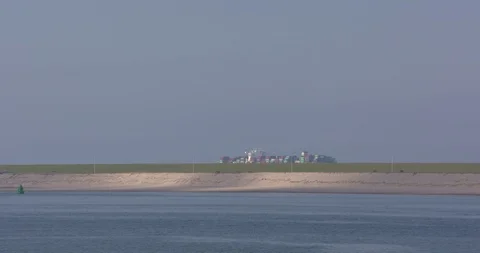 Large container ship sails outbound towering above seadike ROTTERDAM SEAPORT  Stock Footage 114973185