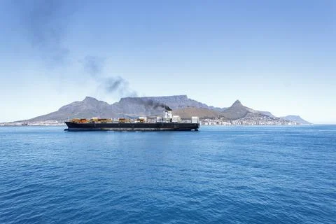 Large container ship at sea in front of Cape Town and Table Mountain. Stock Photos
