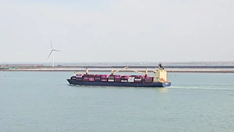 Large container ship steams through busy port stacked with colorful containers Stock Footage 327431409