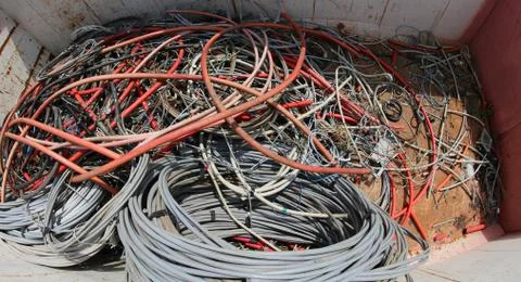 Large containers with many large old high voltage cables in the landfill of r Stockfoto's