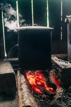 Large cooking pot steaming over a wood fire Foto stock