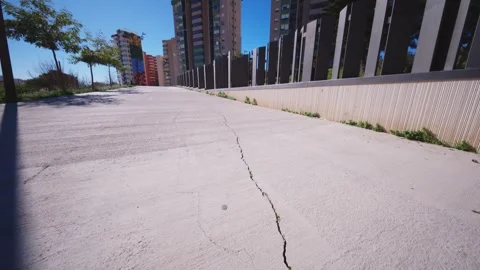 Large Crack in Concrete Sidewalk with Modern Architecture Stock Footage 329607613