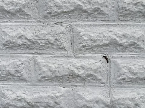 A large crack in a white brick wall Stock Photos
