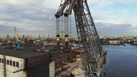 Large crane and hooks with a cargo port and river in the background. Multi-ton Video stock 154417337