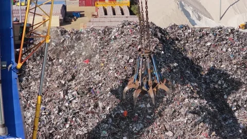 Large crane claw lifts and moves a massive pile of scrap metal at the Port of Vídeos de archivo 346880973