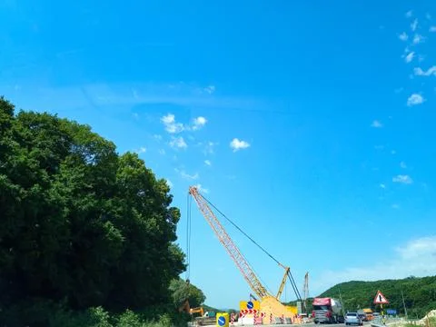 Large crane during the construction of the road. Stock Photos