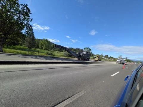 Large crane-equipped roadwork machine parked beside highway Photos