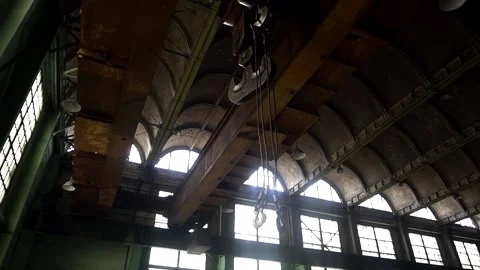 Large crane hooks hang in a large industrial hangar. Stock Footage 145711255