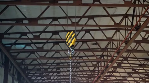 Large crane hooks hang in a large industrial hangar. Stock Footage 246502280