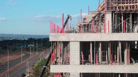 Large Crane loading building material to the top of a New Apartment Building Stock Footage 313637874