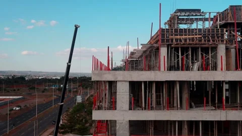 Large Crane loading building material to the top of a New Apartment Building Stock Footage 313637994