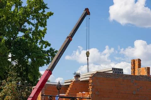 A large crane operates at a construction site, lifting building materials a.. 库存照片