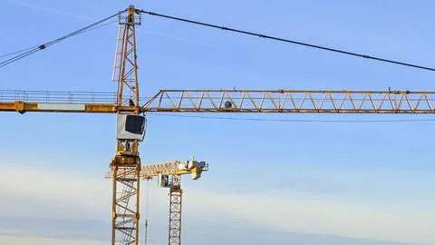 Large crane is in the sky with a blue sky behind it Stock Photos