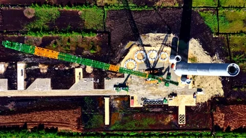 A large crane stretches across a construction site as workers assemble the tall Vídeo Stock 325570708