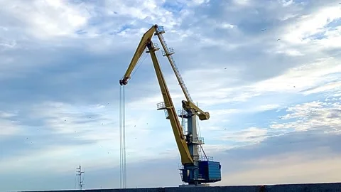 A large crane is working against the sky Stock Footage 250286428