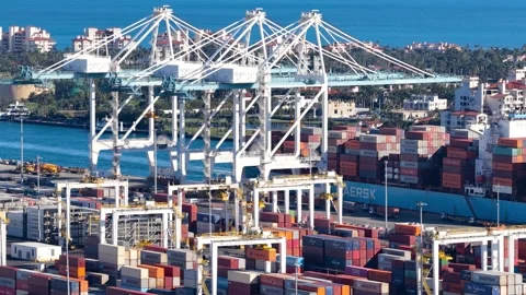 Large cranes moving cargo containers from a vessel at a bustling commercial.. Stock Footage 333602387