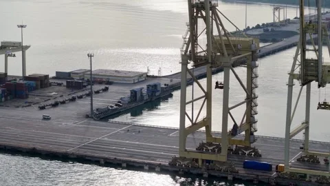 Large cranes stand over busy harbor docks Stock Footage 337669126