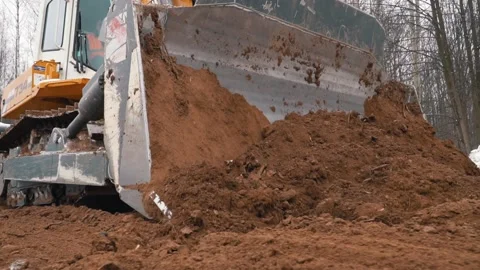 Large crawler with chain tracks pushes brown soil mass 스톡 동영상 154422551