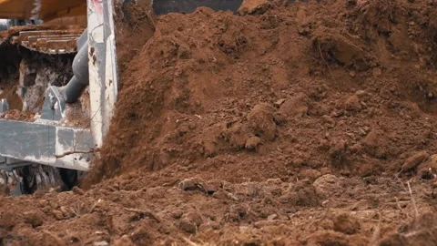 Large crawler with chain tracks pushes brown soil mass Video stock 154747914
