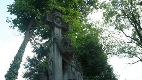 Large cross with the face of jesus on the background of large trees 스톡 동영상 115033092